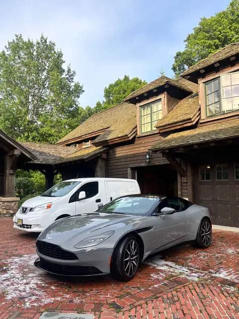 Freshly detailed grey Aston Martin next to the 31 Auto Detailing mobile van