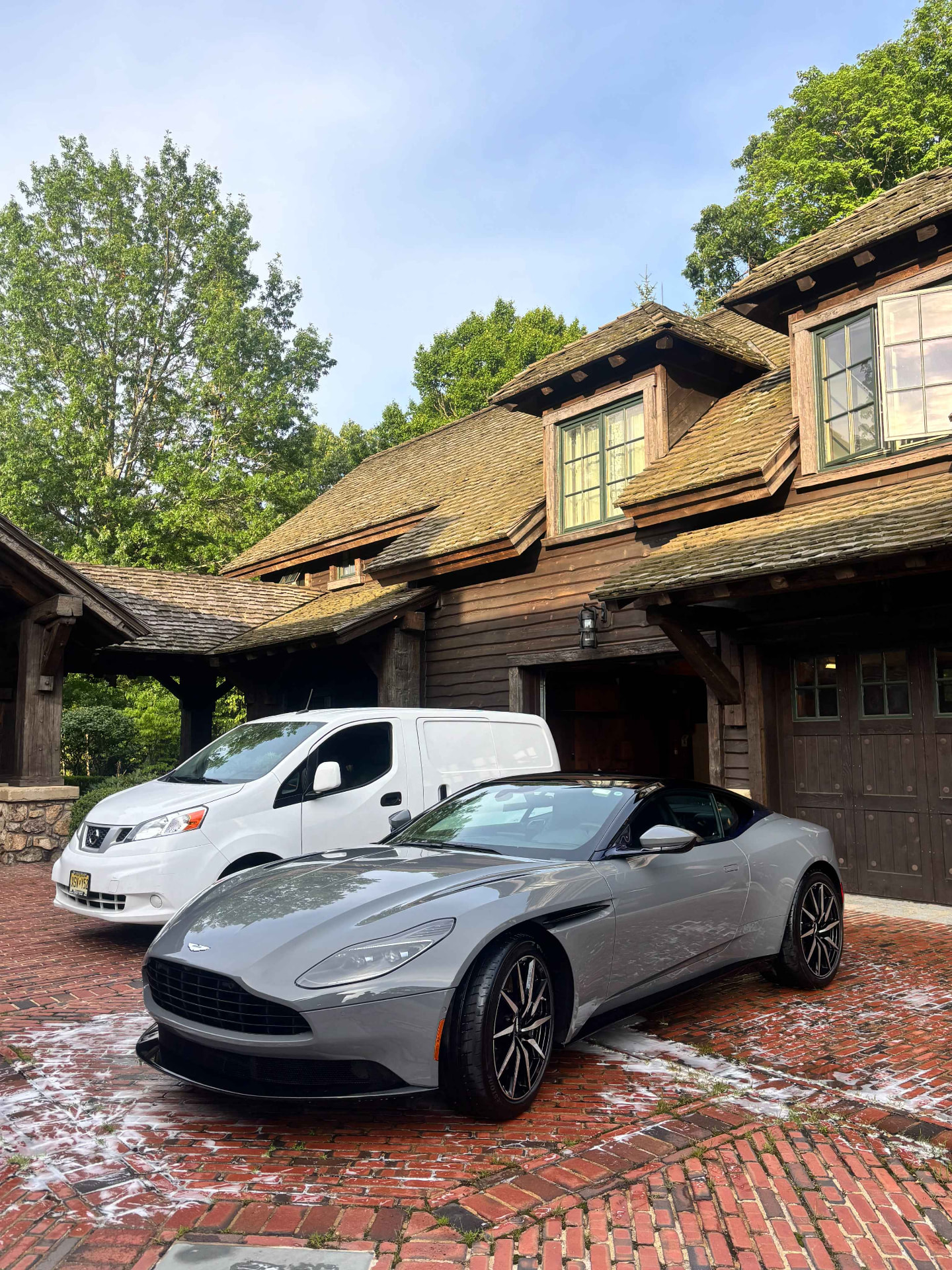 Freshly detailed grey Aston Martin next to the 31 Auto Detailing mobile van